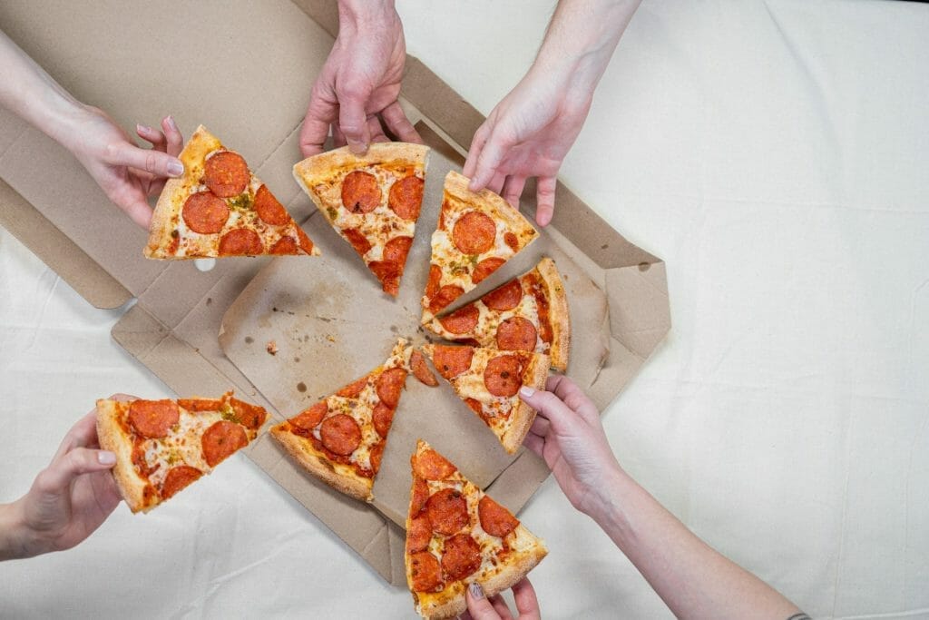 five people sharing a pepperoni pizza.