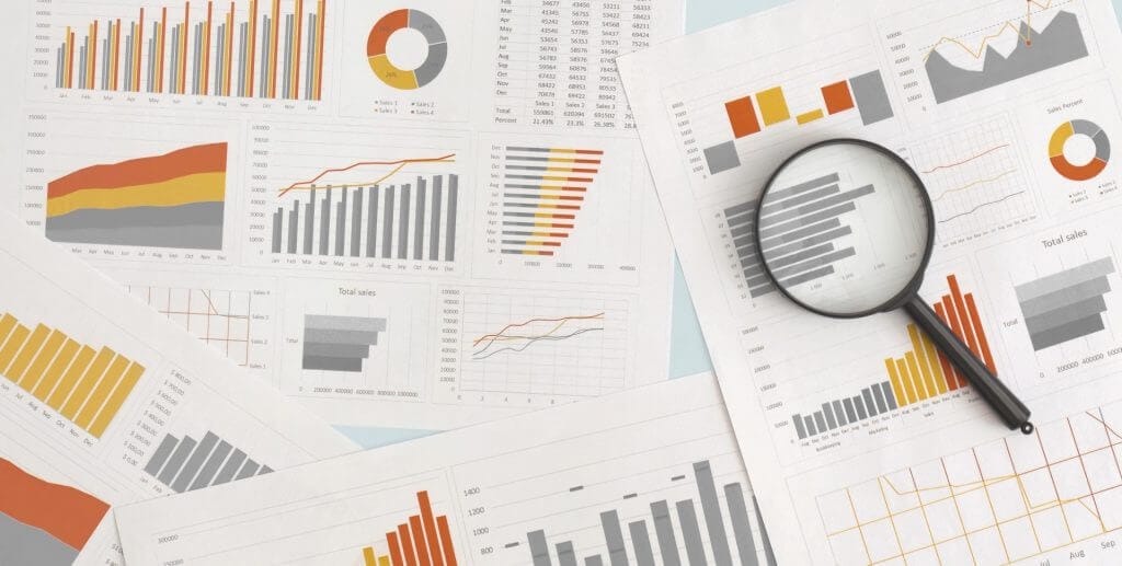 business charts, graphs, and stats under a magnifying glass